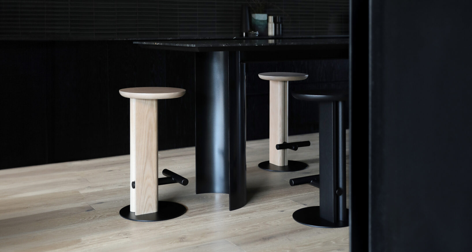 Rook stools in white oak and black-stain oak finish , surrounding a dinning table.